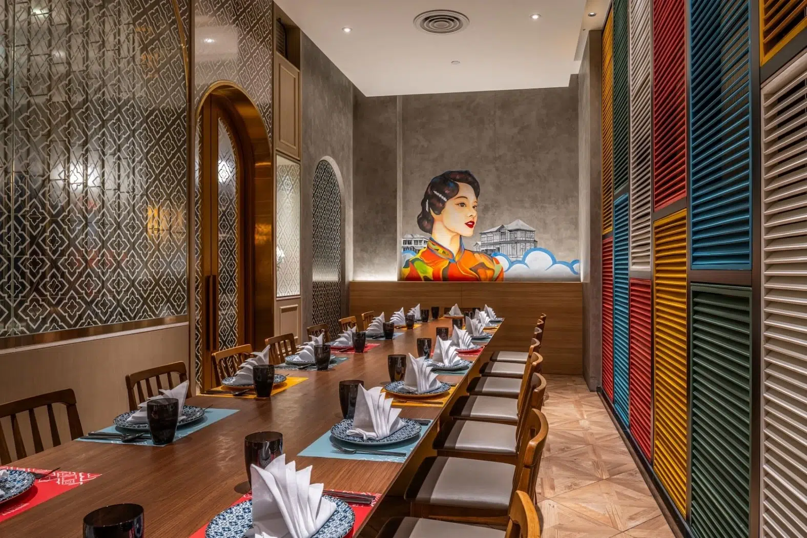 A private dining room with multi-colored walls adorned with paintings of women in traditional Chinese QiPao dresses