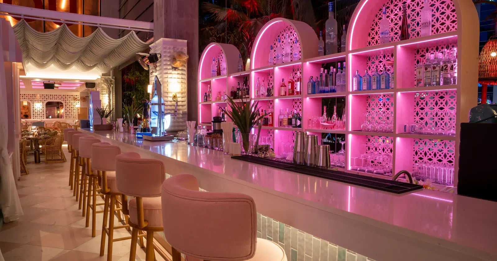 Here’s a photo of Mami Rose bar, located on the 5th floor of EmSphere mall in Bangkok. The restaurant channels the vibe of an upscale Miami spot from the 80s, with a bar illuminated in pink lights and vintage-style pink chairs.