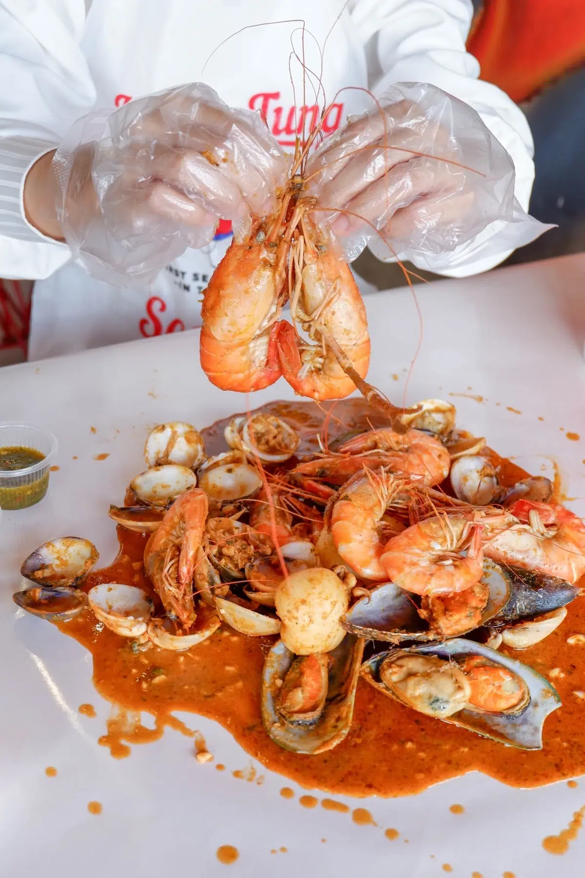 A vibrant, hands-on seafood feast with fresh prawns, mussels, and clams in rich, flavorful sauce at Koongtang restaurant—perfect for seafood lovers.