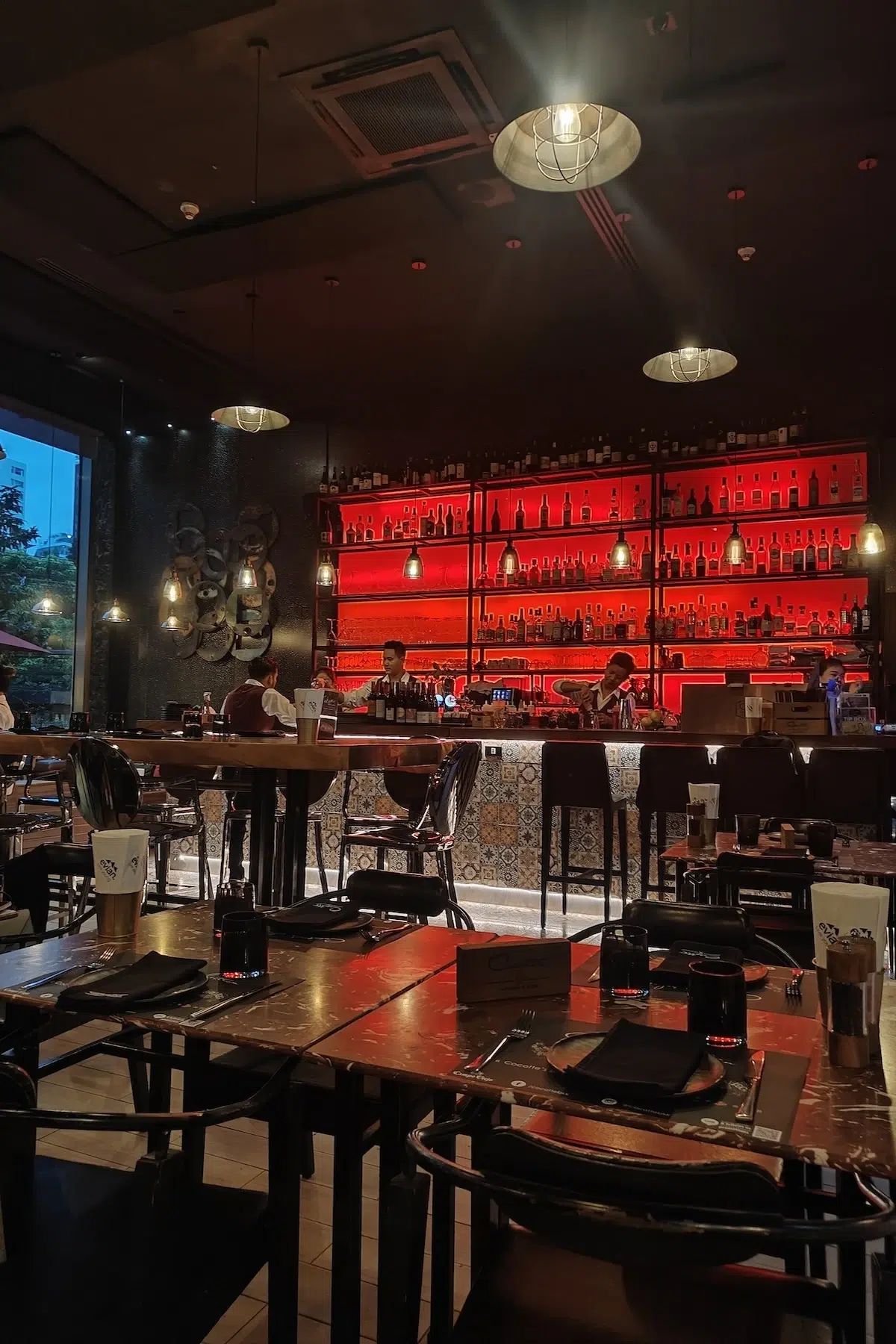 This is the interior of the romantic Cocotte restaurant with subdued red light from the bar