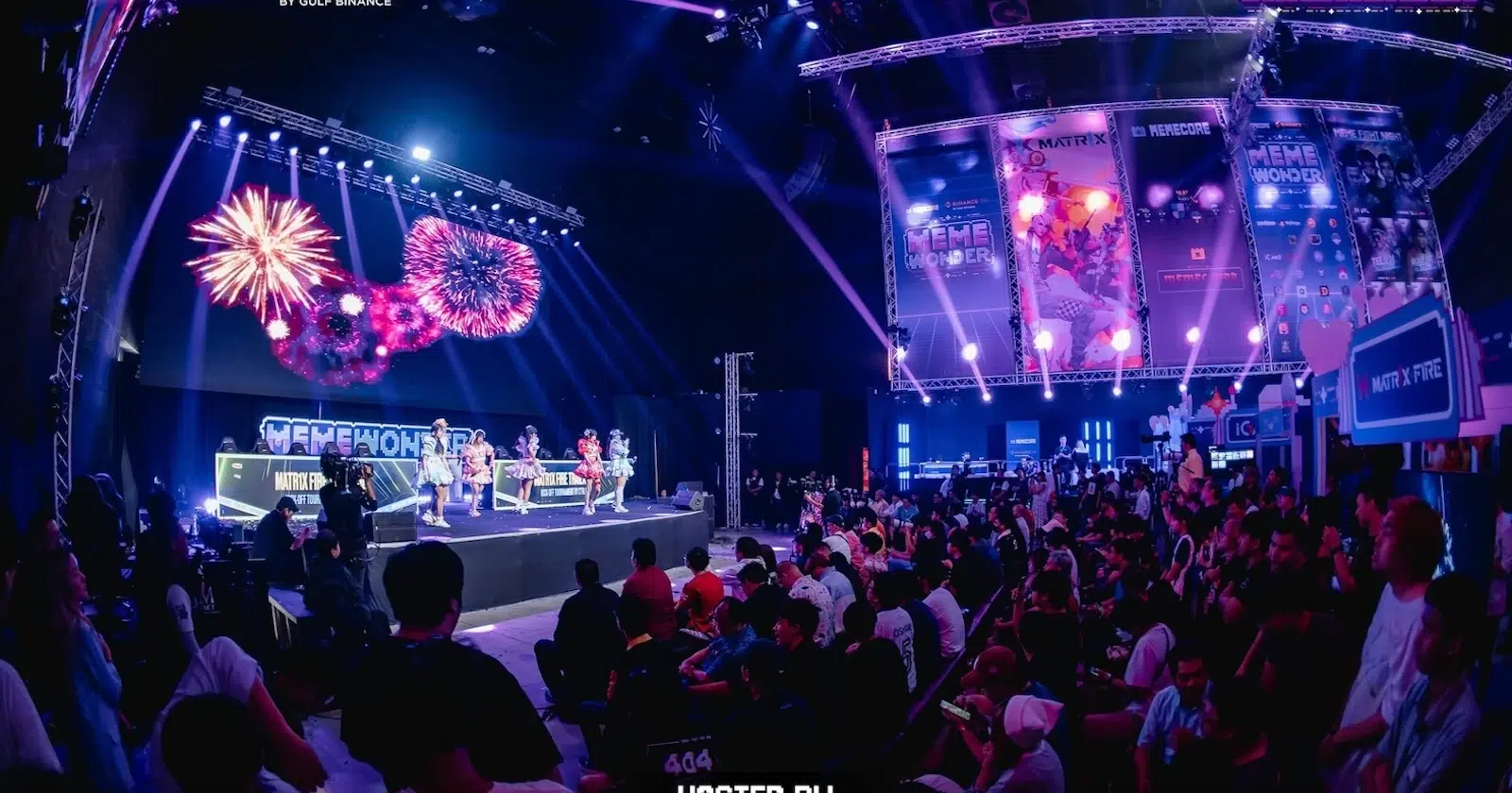 People in the hall seated and watching a performance on stage.