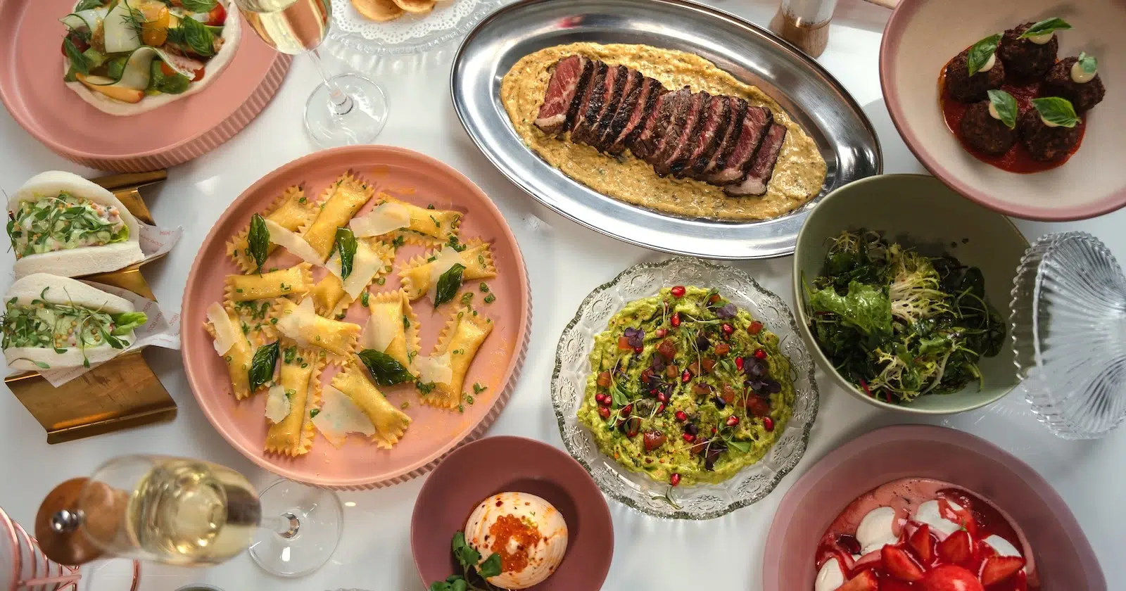 Big table full of food, including Spinash Raviolini and Summer Salad at Mami Rose: The Goodtime restaurant